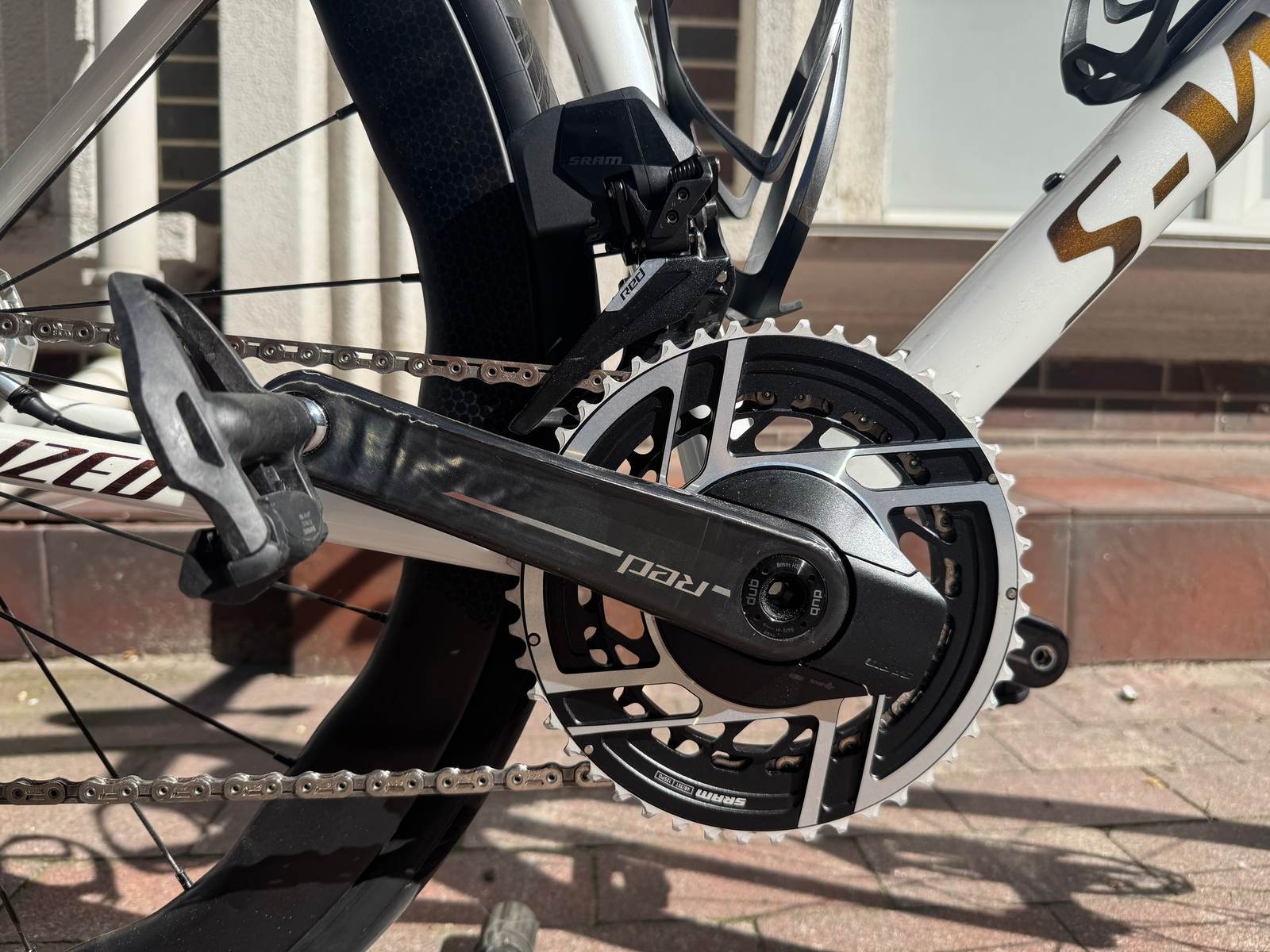 Крупний план системи SRAM RED AXS з павуком паверметра та переднім перемикачем